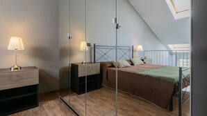 Een slaapkamer met een bed, nachtkastjes, lampen en een dakraam.