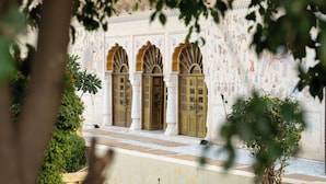 A building facade with three arched doorways, a tiled ground, and a wall with intricate patterns. - Medieval Forts, Kalwar, Jaipur (Jaipur)