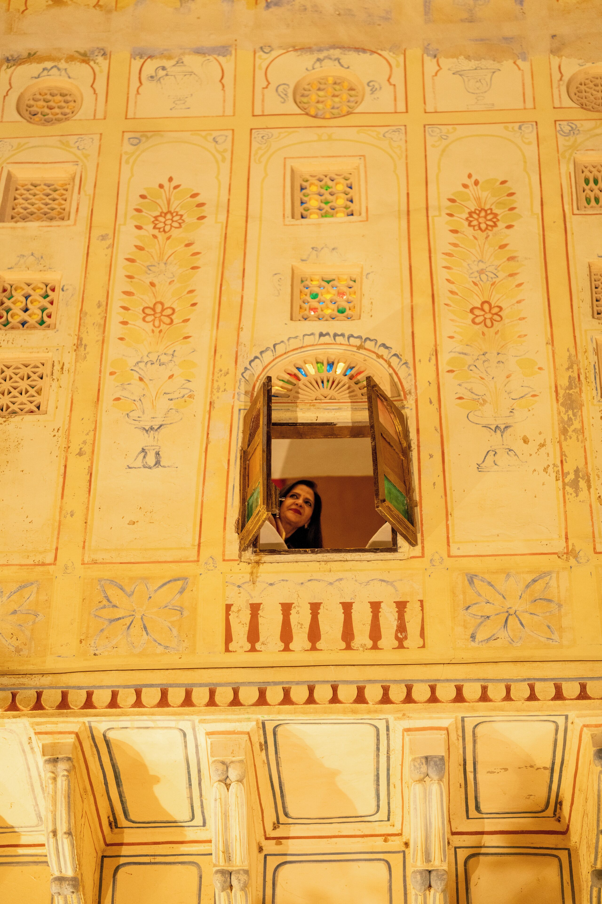 A detailed architectural facade with intricate designs and a window with a decorative frame.