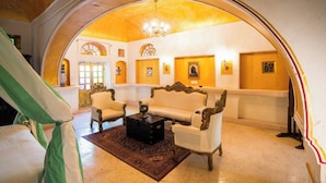 An arched room with ornate furniture, a chandelier, and stained glass windows. - Medieval Forts, Kalwar, Jaipur (Jaipur)
