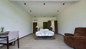 Un dormitorio con cama, escritorio, silla y sofá.