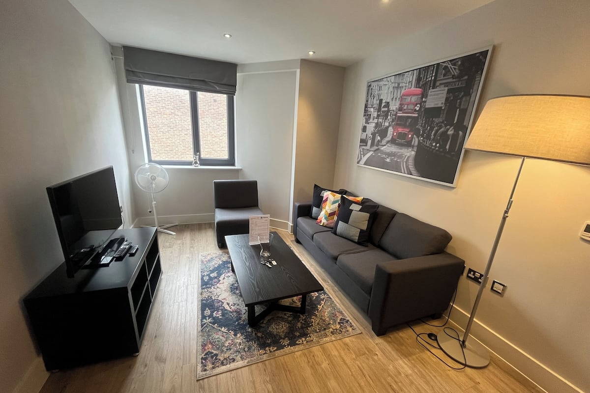 Een moderne woonkamer met een bank, salontafel en televisie.