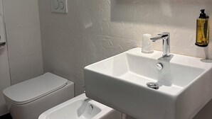 A modern bathroom with a toilet, bidet, and sink. - Dimora della Posta (Mondovì)