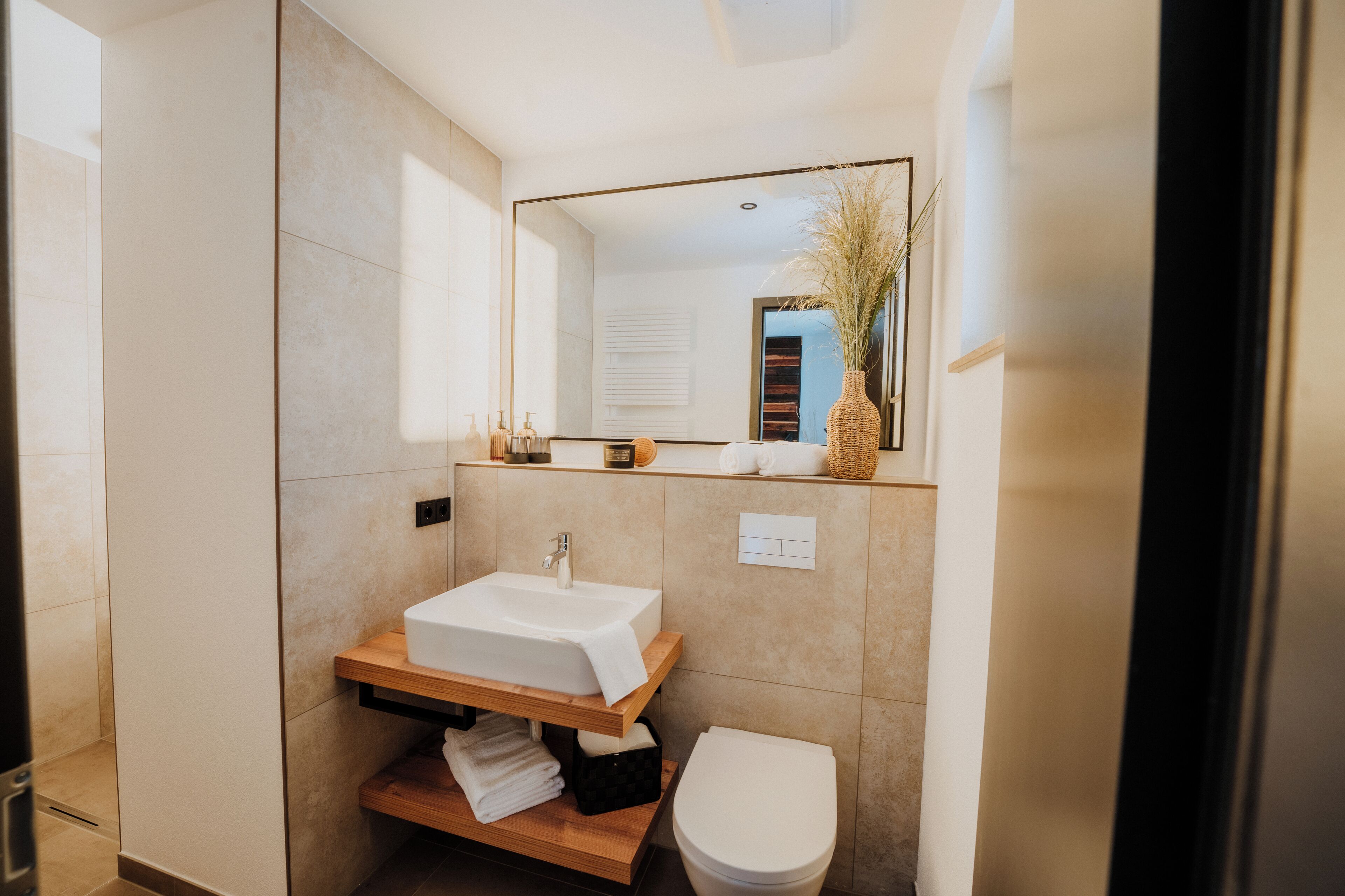 Un baño moderno con lavamanos integrado, inodoro y espejo sobre el lavamanos.