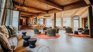 A spacious lobby with wooden ceiling beams, a bar area, and comfortable seating. - WALDGUT Naturresort (Bad Gottleuba-Berggiesshuebel)