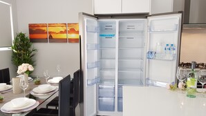 A modern kitchen with a built-in refrigerator, a dining table set for four, and a decorative plant. - Culloton Escape – Spacious 3BR Family Home Near Parks & Shops (Balga)