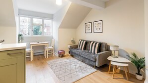 A compact living space with a kitchenette, a dining area, a sofa, and a small table. - Bright and modern East London loft (London)