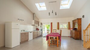 Una cocina amplia con comedor, tragaluces y vistas al exterior.