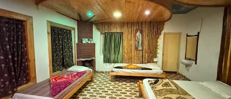 A room with two wooden beds, a brick fireplace, and a patterned floor.