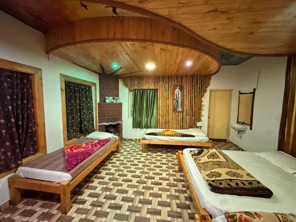 A room with two wooden beds, a brick fireplace, and a patterned floor.