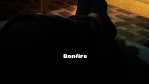 Una habitación con chimenea de ladrillo, una cama y una ventana con barrotes.