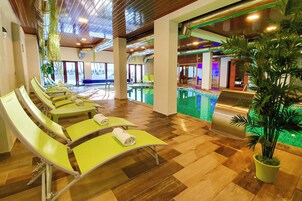 A poolside area with lounge chairs and a grill.