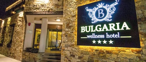 Un edifici de pedra amb un cartell del Wellness Hotel Bulgaria.