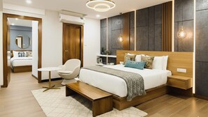 Un dormitorio moderno con una cama grande, mesitas de noche, una silla y una pequeña mesa.