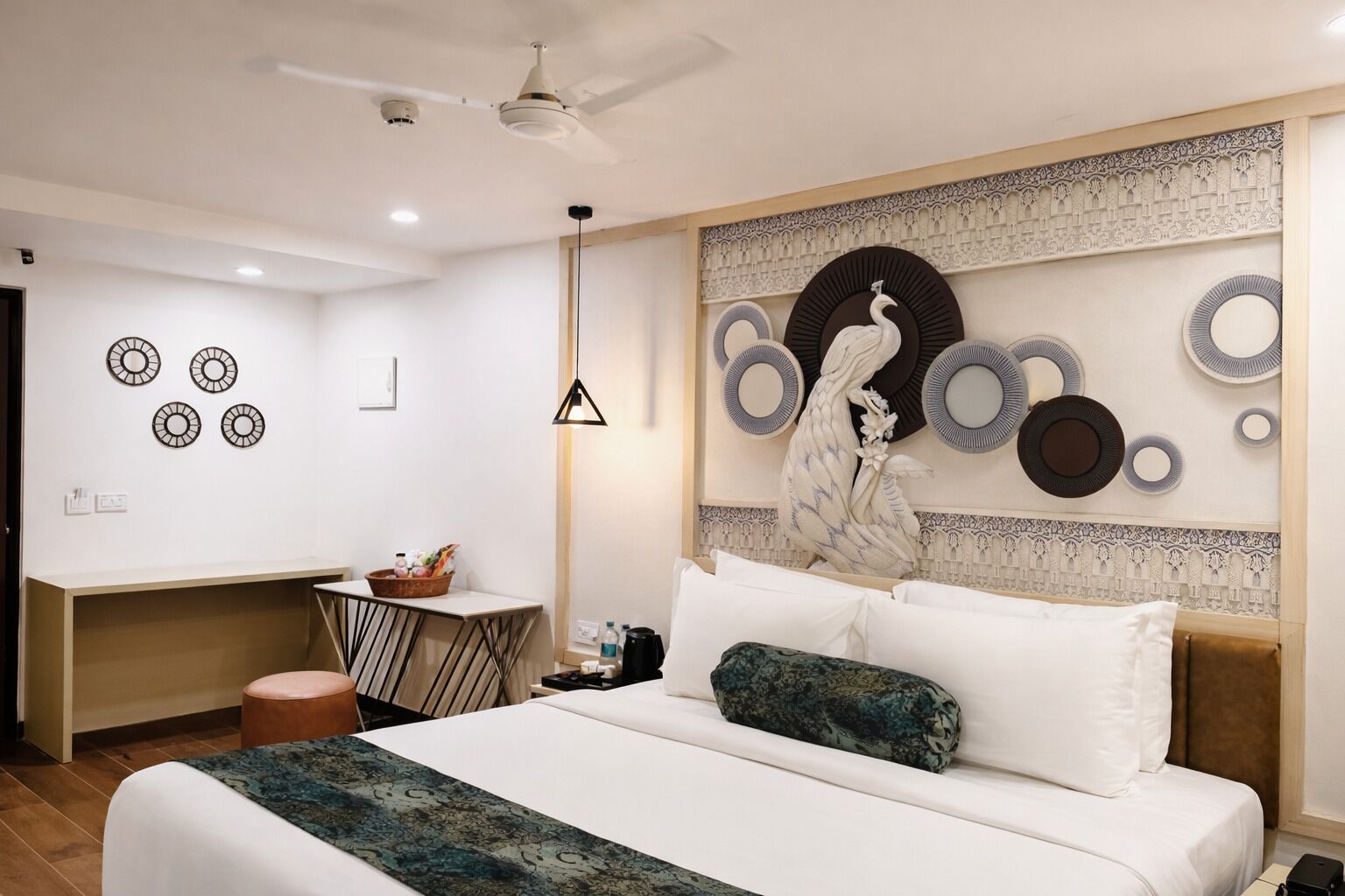 Une chambre moderne avec un grand lit, un bureau et un mur décoratif.