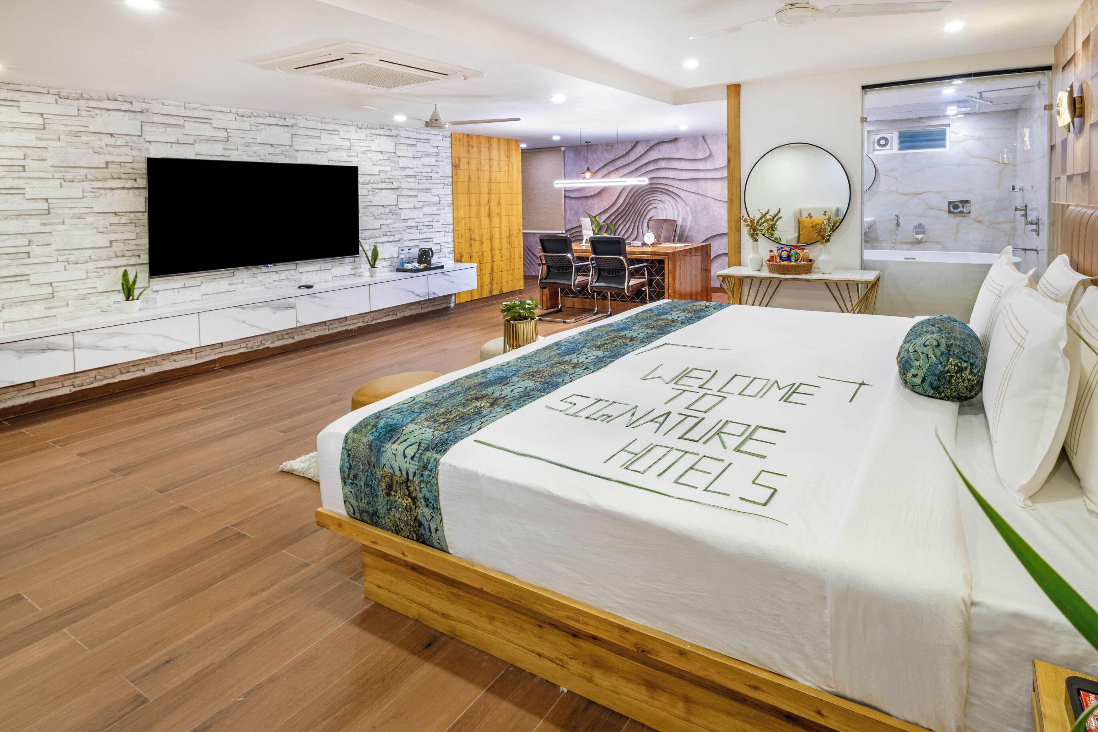 Una habitación de hotel moderna con cama, escritorio, televisor y baño.