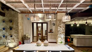 A dining area with a stone wall, a wooden ceiling, and a table set for four.