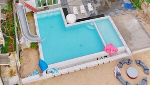 Una casa moderna de dos pisos amb piscina, porxo cobert i un petit jardí.