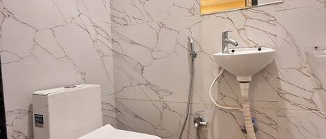 A bathroom with a toilet, sink, and shower.