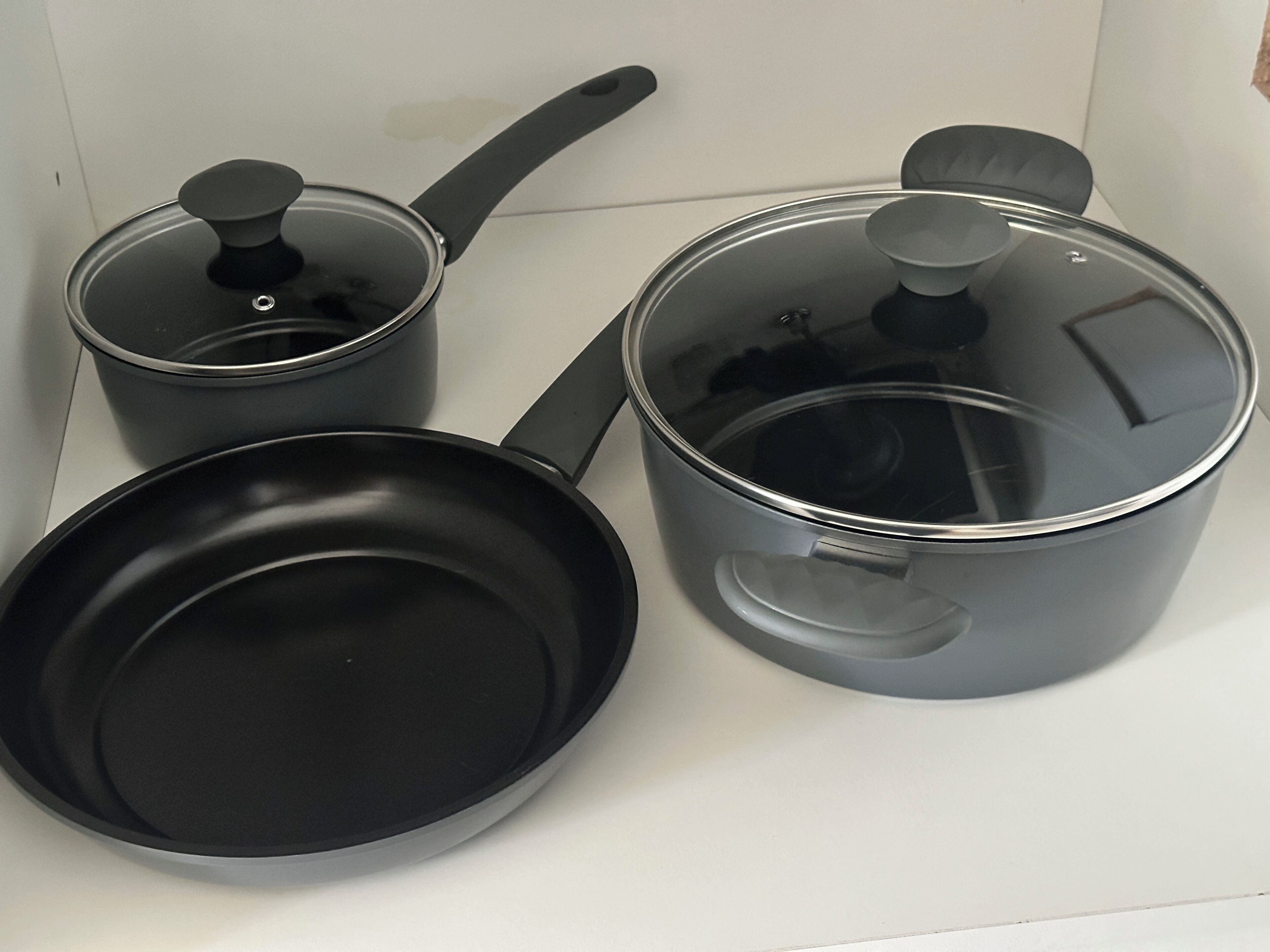 A kitchen with a stove, a frying pan, and a pot.