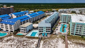 Un complexe hôtelier comprenant plusieurs bâtiments, une piscine et une plage.