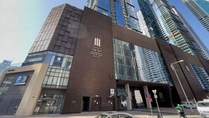 A modern building with a prominent entrance, large glass windows, and a sign indicating it is a residential complex. - Luxury 1BR in Marina Gate with Infinity Pool (Dubai)