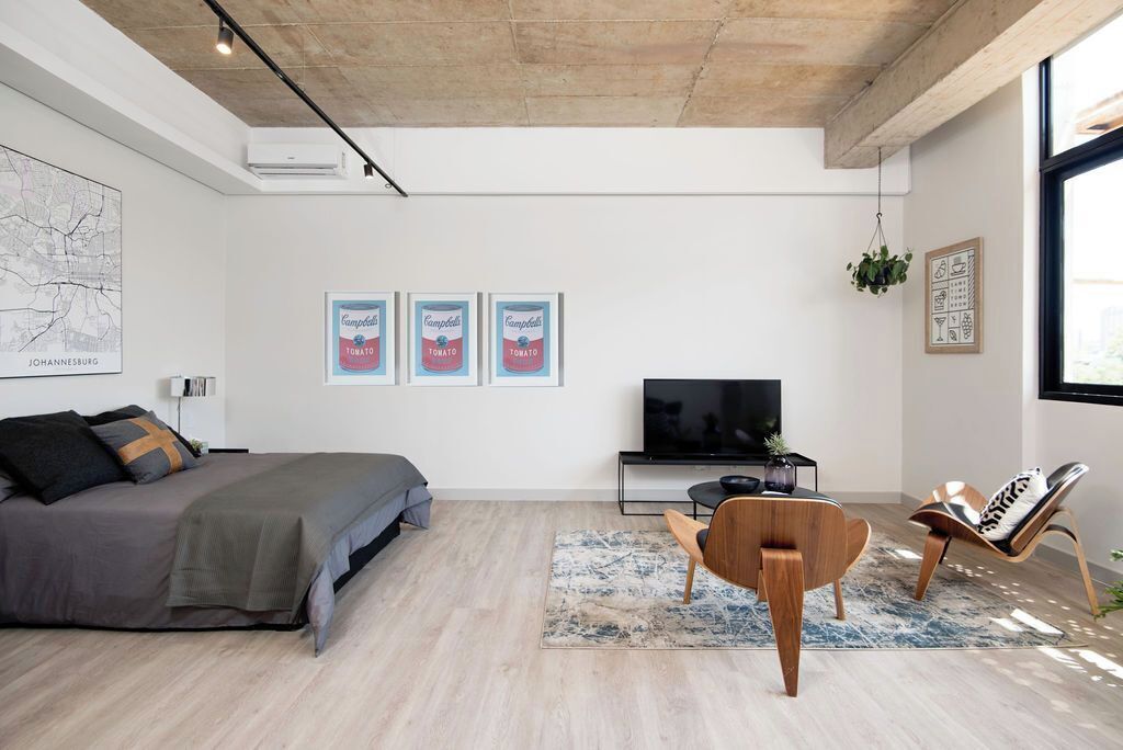 Una sala de estar moderna con una cama, un televisor y una mesa de centro.