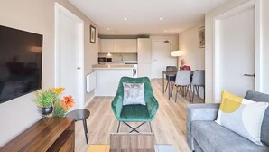 A modern apartment with a living room, dining area, and kitchen.