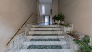 A marble staircase with a handrail, leading to a room with a door and a window. - Casa Andreis by Wonderful Italy (Turin)