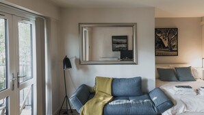 A modern living room with a sofa, a coffee table, and a large window.