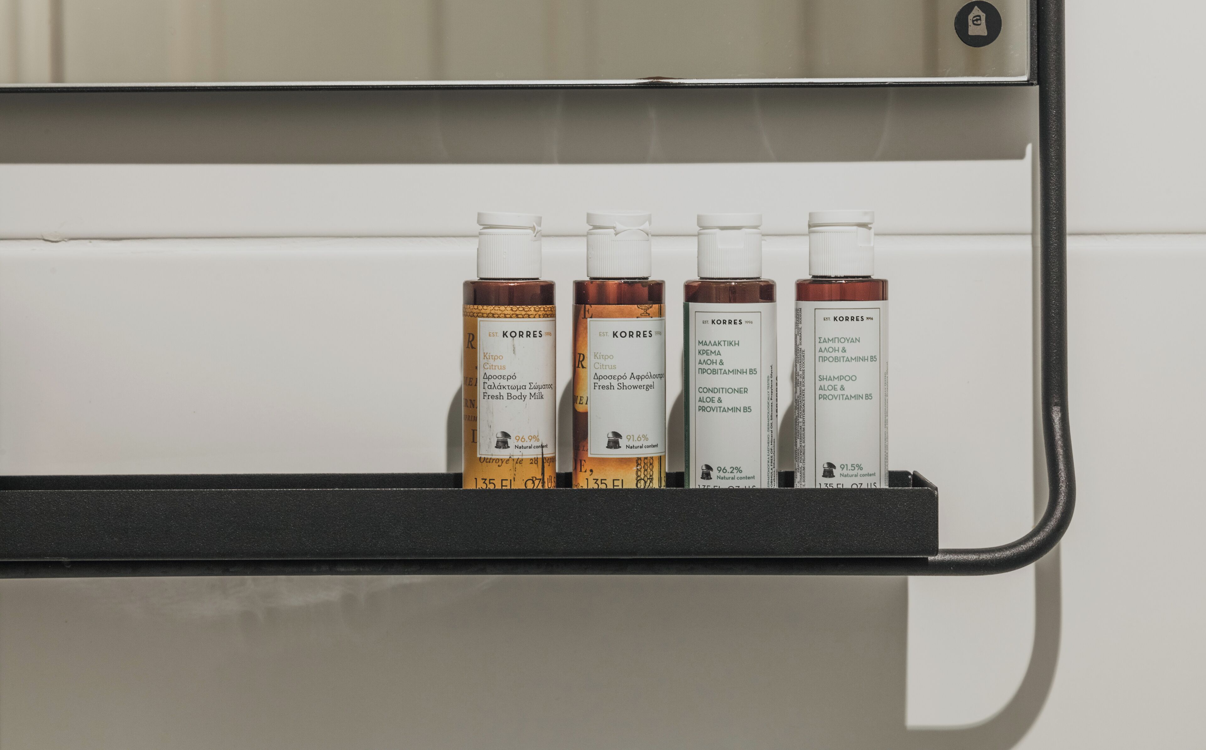 Uma prateleira com quatro frascos de produtos Korres.