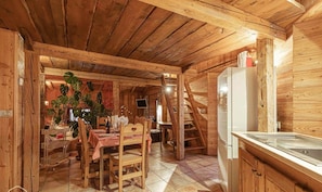 A wooden cabin interior with a dining area, kitchen, and staircase. - Charming apartment in Lodenou - Sleeps 7 - Aussois (Aussois)