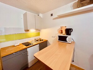 A compact kitchen with a microwave, coffee maker, and a small sink. - Studio/ terrace "le Plan sec", 3 pers Aussois (Aussois)