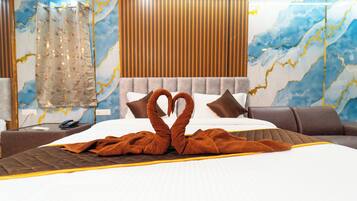 A hotel room with a large bed, a wooden headboard, and a marble-patterned wall.