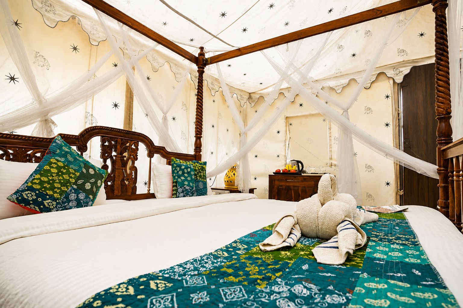 A four-poster bed with a canopy, a wooden headboard, and a patterned bedspread.