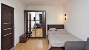 A bedroom with a bed, a dresser, a desk, and a wardrobe. - Mashtots  apartment by Luxe Group MA154 (Yerevan)