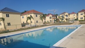 A swimming pool with a tiled edge, surrounded by a concrete deck.