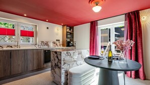 Una cucina moderna con ripiani in marmo, forno integrato e zona pranzo con tavolo rotondo.