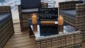 Un'accogliente area esterna con mobili in vimini e un cartello che indica la temperatura della spa.