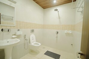 A bathroom with a sink, toilet, shower, and tiled floor. - Hotel The Vibez Inn (Jabalpur)