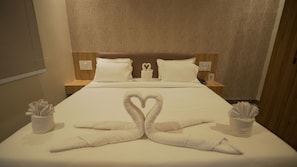 A hotel room with a neatly made bed, two nightstands with lamps, and a wall with a textured pattern.