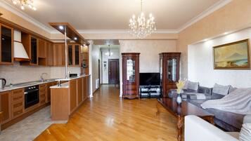 Apartamento básico, 1 habitación | Zona de estar | Televisión de pantalla plana de 50 pulgadas con canales por cable