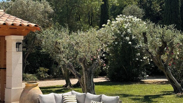 A patio with a sofa and a table, surrounded by a garden with trees and a clear sky. - Escape to Elegance -Wonderful Mas Provencal in the heart of the Alpilles (Saint Etienne du Grés)