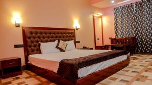 A neatly made bed with a wooden headboard, a bedside table, and a nightstand. - Hotel Ronak  By Red Panda (Gangtok)