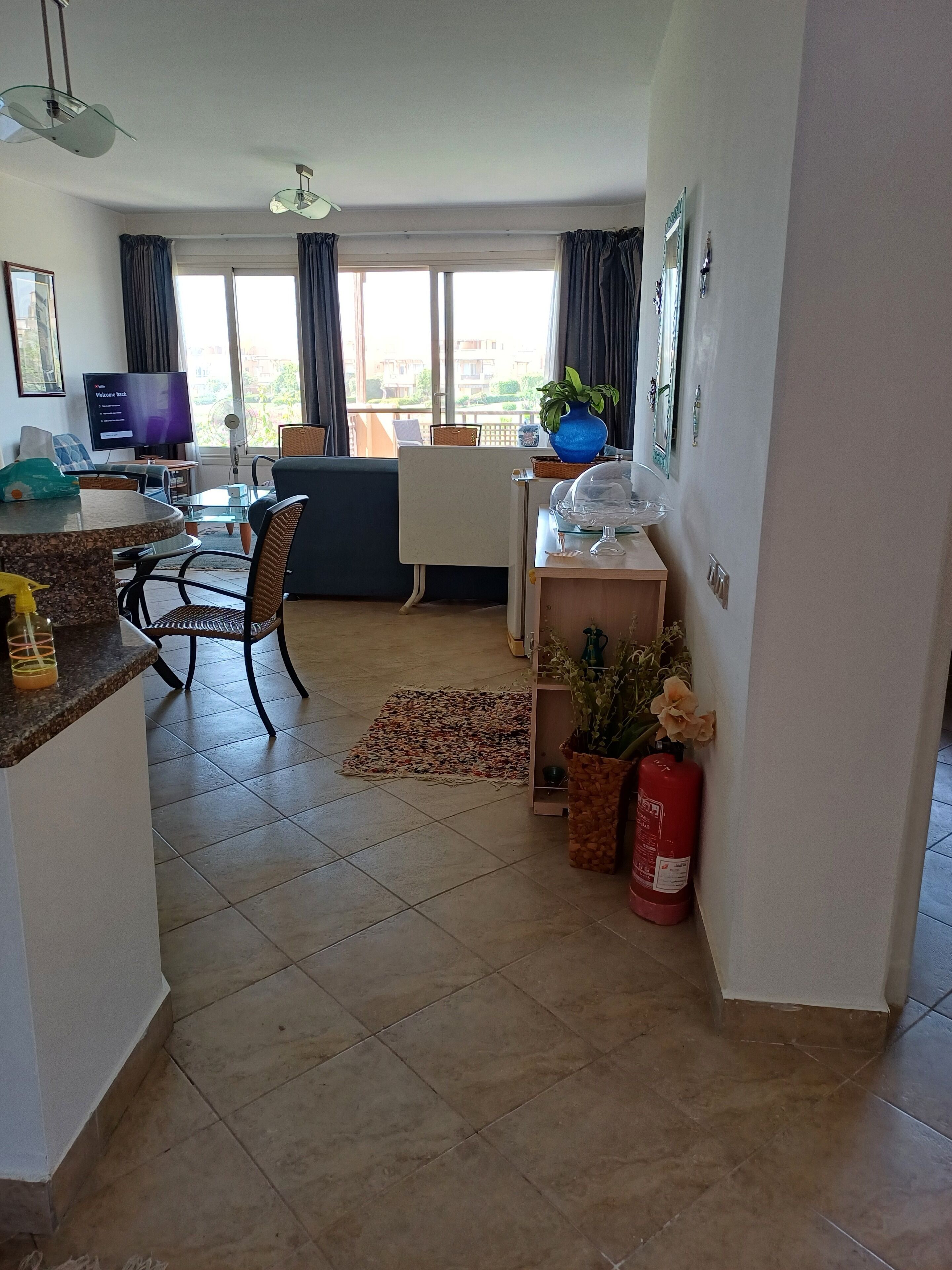 A living room with a TV, dining area, and a view of the outside.