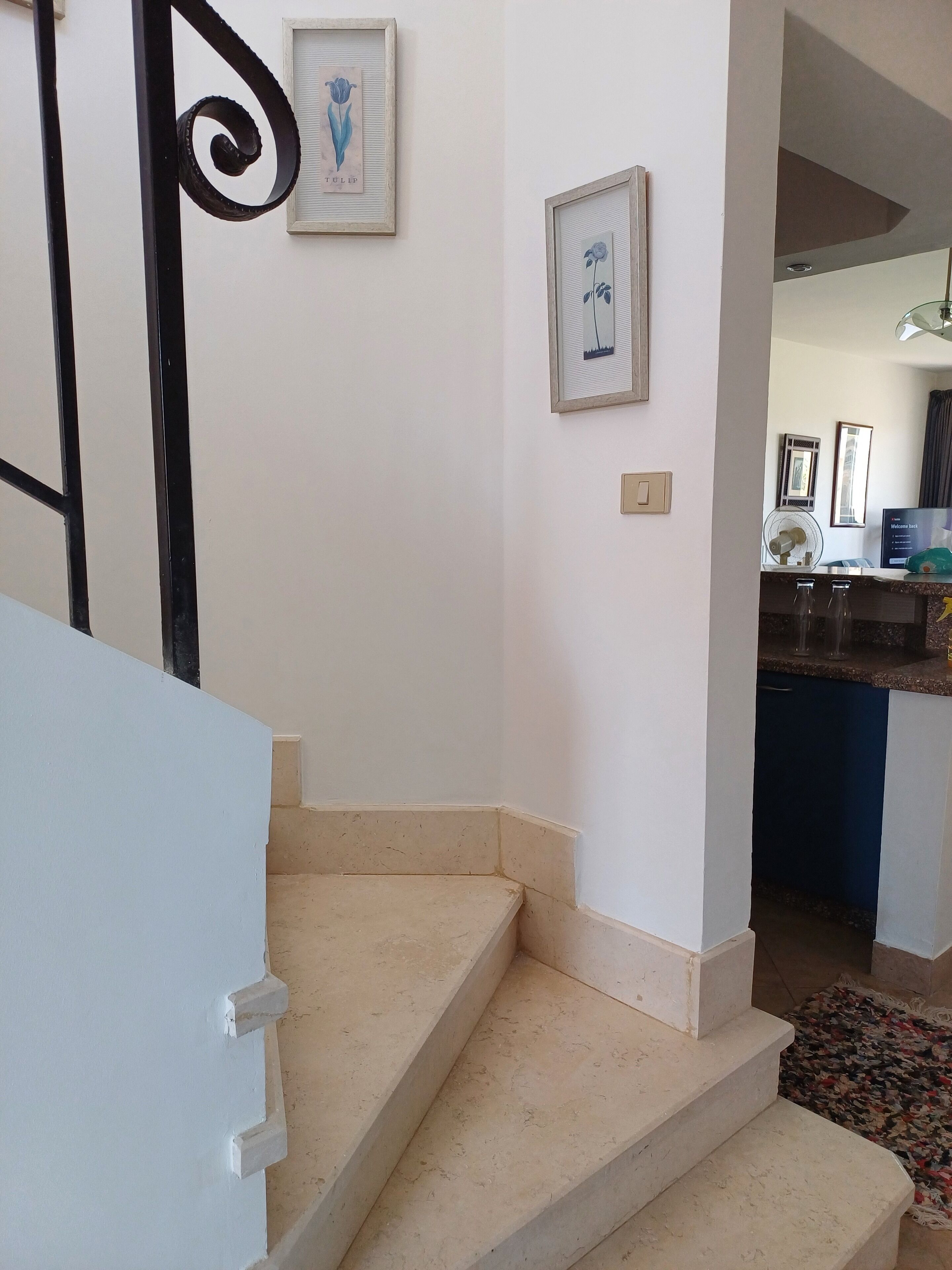 A staircase leading to a room with a kitchen area visible in the background.