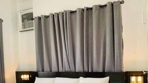 A neatly made bed with white linens, a dark headboard, and two bedside lamps. - 3 Bed Apartment at a Central Location (Ibadan)