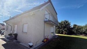 A two-story house with a balcony, a garage, and a small garden area. - House in Hannover/Laatzen! contactless check-in (Laatzen)