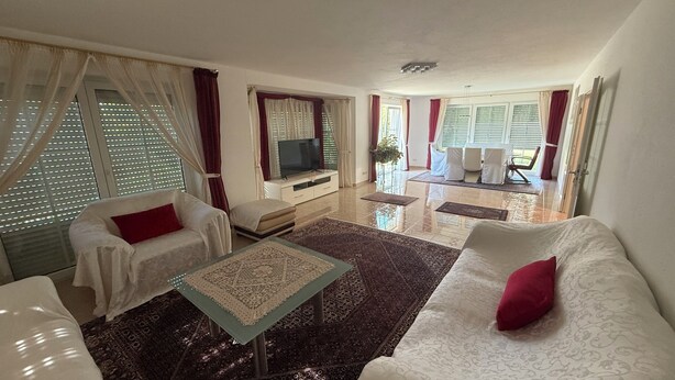 A living room with a sofa, a coffee table, and a TV. There is a dining area with a table and chairs. - House in Hannover/Laatzen! contactless check-in (Laatzen)