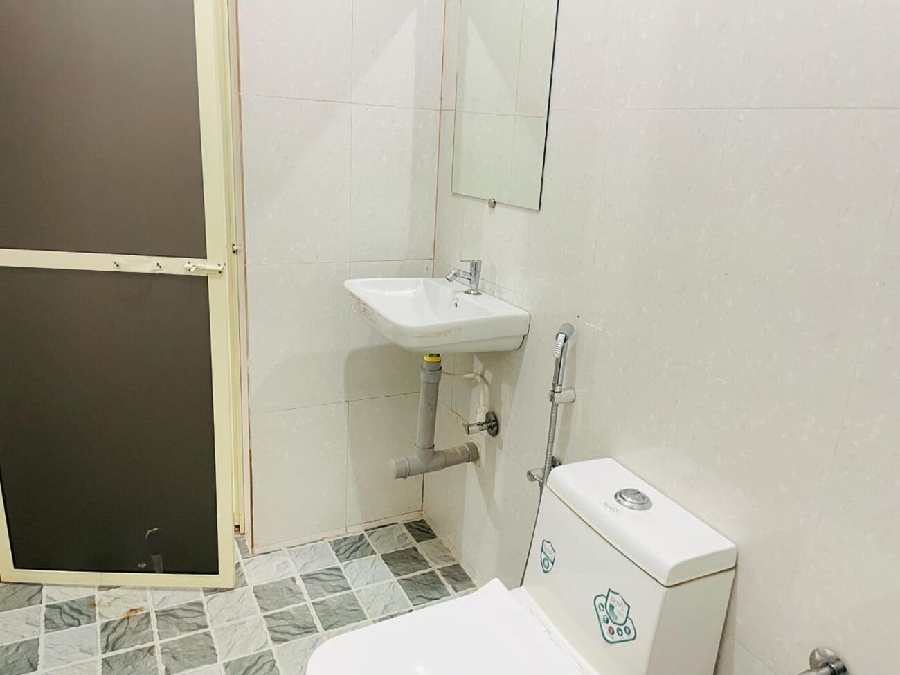 A bathroom with a white sink, a toilet, and a shower area.